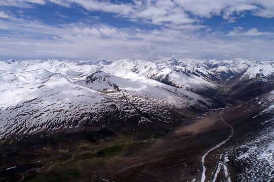 Aerial view of the snow-covered peaks and winding mountain road at Babusar Top in Naran, Khyber Pakhtunkhwa, Pakistan.