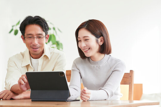 リビングでタブレットPCを見る女性と男性