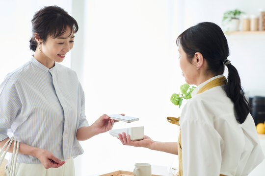 カフェでタッチ決済をする女性と店員