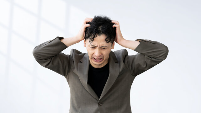 頭を抱えて悩む男性ビジネスマン, Stressed Businessman Holding His Head