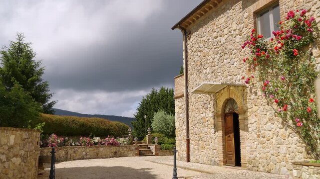 Stone House With Climbing Roses in Tuscan Countryside Courtyard Under Stormy Sky in Amelia, Umbria, Italy