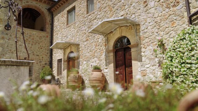Sunlit Tuscan Stone Villa Entrance With Wooden Doors, Terracotta Pots and Rustic Courtyard Garden in Amelia, Umbria, Italy