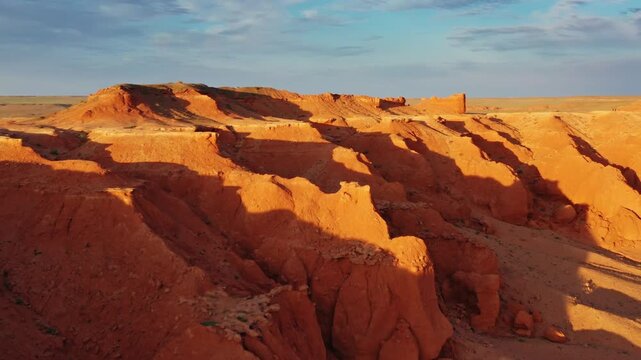Aerial view of the red sandstone formations of the Flaming Cliffs at sunset in Bulgan, Omnogovi, Mongolia.