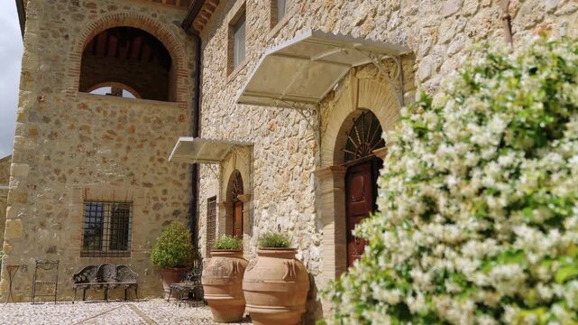Sunlit Tuscan Stone Villa Entrance With Wooden Doors, Terracotta Pots and Rustic Courtyard Garden in Amelia, Umbria, Italy