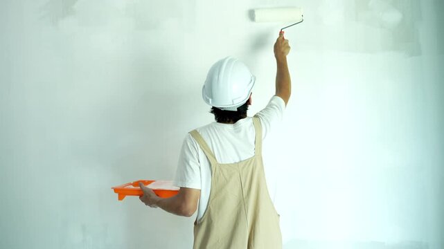 painter man, brush in hand for products to restore and paint the wall, indoor the building site of a house, wall during painting, renovation, painting, contractor, Architect, construction worker