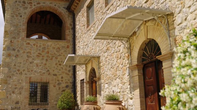 Sunlit Tuscan Stone Villa Entrance With Wooden Doors, Terracotta Pots and Rustic Courtyard Garden in Amelia, Umbria, Italy