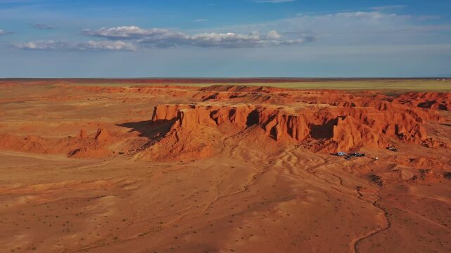 Aerial view of the red sandstone Flaming Cliffs in the Gobi Desert, featuring dramatic rock formations and arid terrain in Bulgan, Omnogovi, Mongolia.