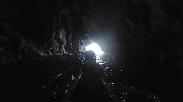 Woman Kayaking Into Sea Cave Paddling Adventure Along Rocky Coastal Formation near Amalfi Coast, Italy