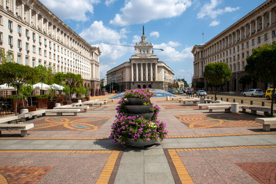 View of the Largo complex with its neoclassical buildings, a central flower planter, and a pedestrian square in Sofia, Sofia City Province, Bulgaria.