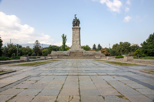 View of the Monument to the Soviet Army with its bronze figures atop a stone pedestal, set in a large paved square surrounded by trees in Sofia, Sofia City Province, Bulgaria.