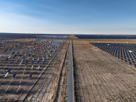 aerial view of solar panel arrays along a desert highway road