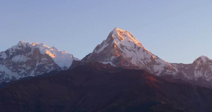 Annapurna region, Nepal, Panoramic drone shot of snow-capped Dhaulagiri Massif illuminated by warm golden sunrise light.