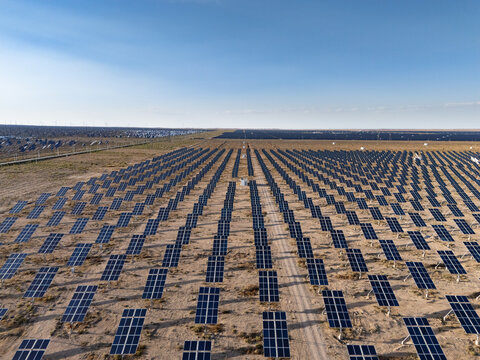 Aerial view of vast solar power plant with neat rows of photovoltaic panels