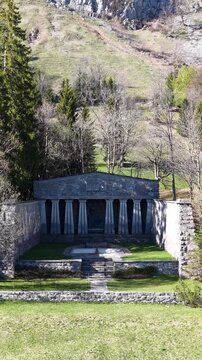 Detailed aerial view of Paxmal, the temple-like peace monument created by Swiss artist Karl Bickel, set in a secluded alpine meadow beneath the towering Churfirsten above Walensee.