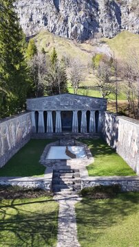 Aerial view of Paxmal, Karl Bickel's monumental peace memorial at Schrina-Hochrugg above Walenstadtberg, framed by the dramatic limestone cliffs of the Churfirsten in Switzerland.