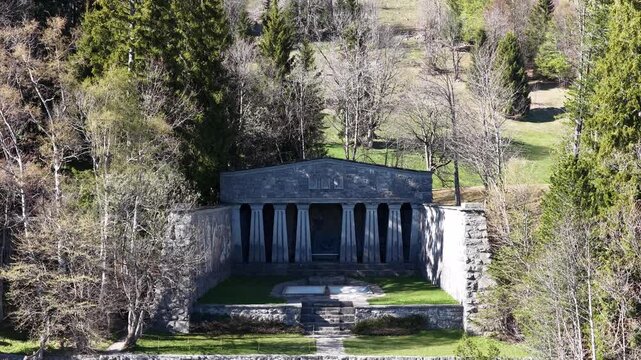 Paxmal Switzerland aerial drone pullback view from stone temple monument forest meadow landscape alps.
