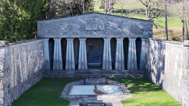 Paxmal Switzerland aerial drone close stone temple facade murals columns inscription monument landscape, drone pullback view.
