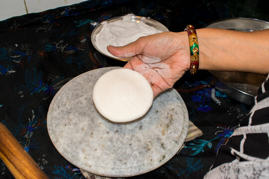lady hand showing rolled round white rice dough, making traditional anarsa at kitchen