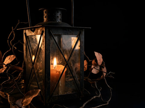 Antique Lantern with Glowing Candle Flame in Dark Moody Halloween Setting