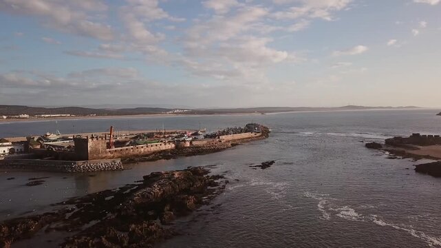 Aerial view of the historic harbor and stone fortifications along the Atlantic coast in Essaouira, Marrakesh-Safi, Morocco.