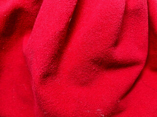 Close up of bright red fleece fabric background with soft folds and textured surface  © plungzby