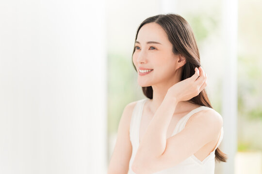鏡を見ながら髪を触る日本人女性