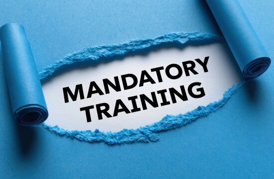 Torn blue paper revealing mandatory training text on white surface