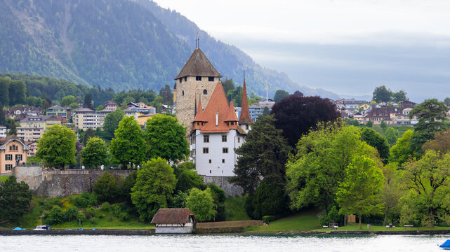 Spiez Castle on Lake Thun, Switzerland, surrounded by mountains