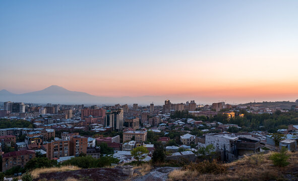 Cityscape photograph of Yerevan city skyline with Mount Ararat view at sunset from Yerevan Cascade in Armenia.