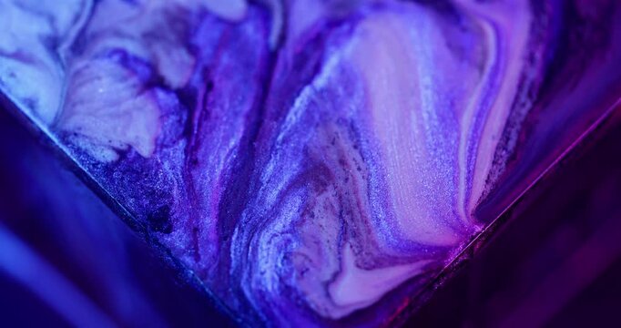 Ink splash. Shimmer blend. Defocused blue purple neon color sparkling texture spilling on abstract acrylic creative background.