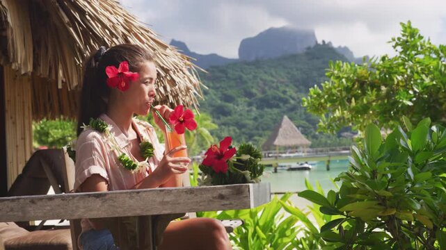 Breakfast at luxury on beach. Woman drinking fruit juice on summer vacation travel in Bora Bora island, Tahiti French Polynesia. Raw video of real unretouched woman model without any makeup