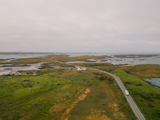 Aerial view of the coastal landscape of South Uist in the Outer Hebrides, with a road, scattered lochs and small rural settlements across the island terrain - South Uist, United Kingdom - 3 aug 2026 © IBRESTER