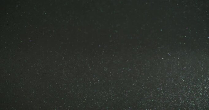 Bokeh light. Round circles. Defocused gray purple color optical lens flare glisten motion on abstract dark black dazzle background.