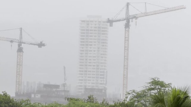 It is raining. Cumulus congestus. City of Honolulu, Oahu, Hawaii. Trade Wind. Tower crane at a construction site