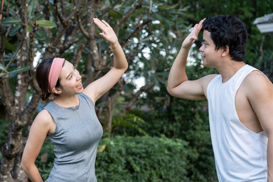 Couple stretching together in a park during morning exercise routine.