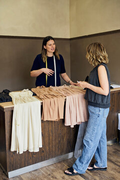 Boutique Owner Consulting with Customer at Clothing Counter