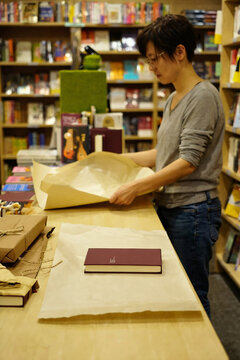 Independent Bookstore Owner Wrapping a Book