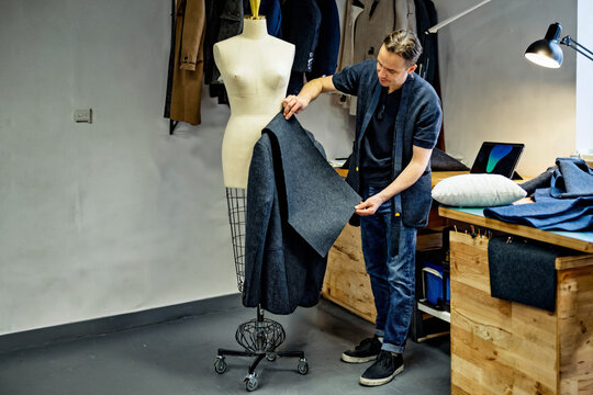 Tailor working on a wool coat in a professional studio