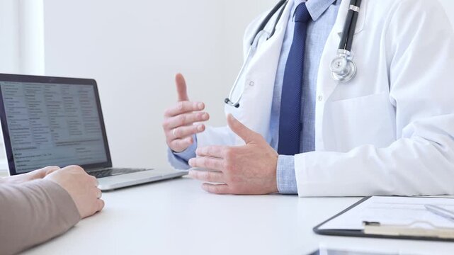 Doctor reviewing digital test results with patient, discussing health findings on laptop screen during clinical consultation. Medicine and health care concept.