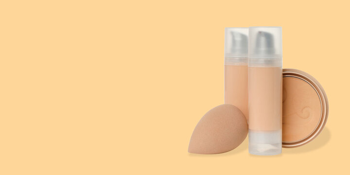 Cosmetics. Cosmetics are neatly placed near a soft sponge on a warm background