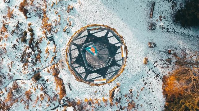 Aerial view of the Svetly vrch observation tower surrounded by snow-covered terrain in Albrechtice v Jizerskych horach, Liberecky kraj, Czechia.