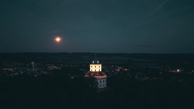 Aerial view of Humprecht hunting lodge illuminated at night under a full moon in Sobotka, Kralovehradecky kraj, Czechia.