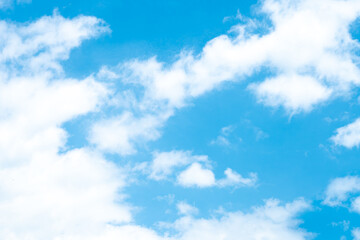 Fototapeta premium Vibrant blue sky with soft white fluffy clouds on a bright sunny day. Scenic natural cloudscape background asset with copy space for banner and graphic design.