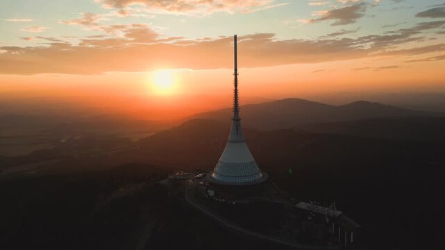 Aerial view of Jested Tower at sunset with rolling hills and warm golden light in Liberec, Liberecky kraj, Czechia.