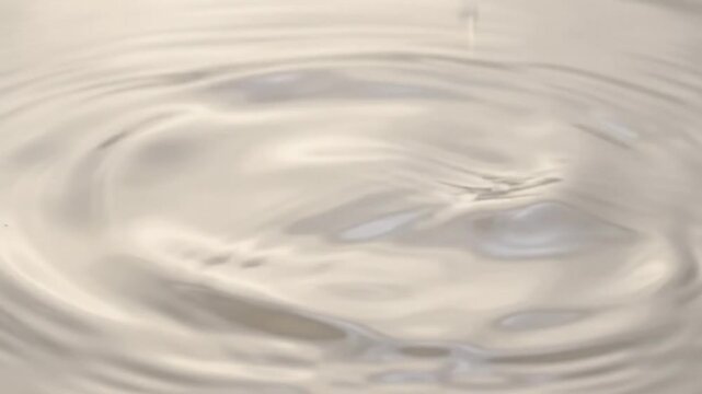 abstract milk drop ripples expanding concentric circles liquid creamy motion macro slow motion