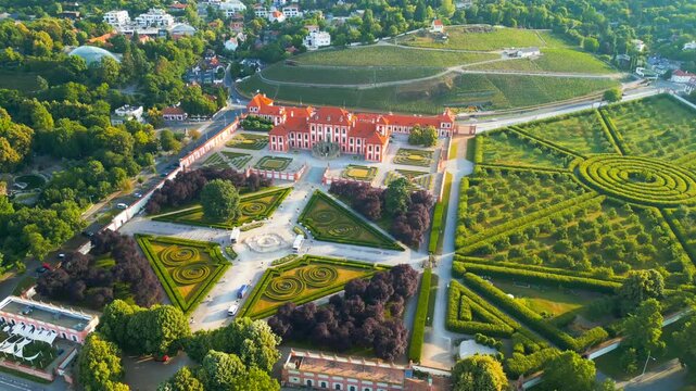 Aerial view of Troja Palace with its symmetrical baroque gardens, manicured hedges, and surrounding greenery in Hlavni mesto Praha, Czechia.