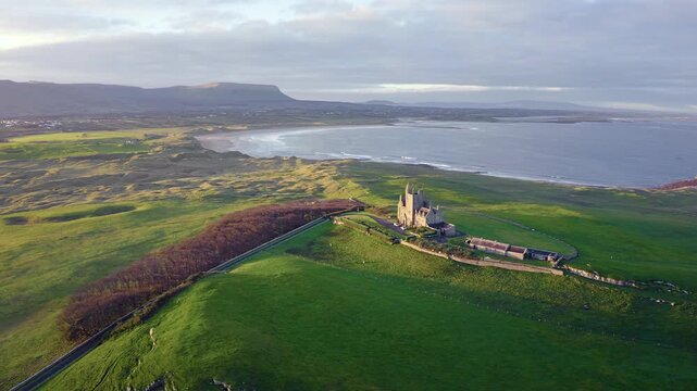 Aerial view of Classiebawn Castle surrounded by green fields and coastal cliffs during golden hour in Sligo, Co. Sligo, Ireland.