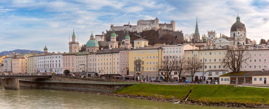 Panoramic view of Salzburg historic architecture along the Salzach River with Hohensalzburg Fortress above the city, Austria.