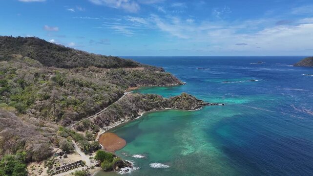 Aerial view of tropical bay with clear turquoise water and coastline road in St Lucia.