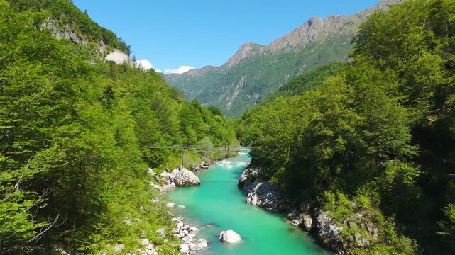 Aerial view of Soca river flowing through lush green valley in Slovenia.